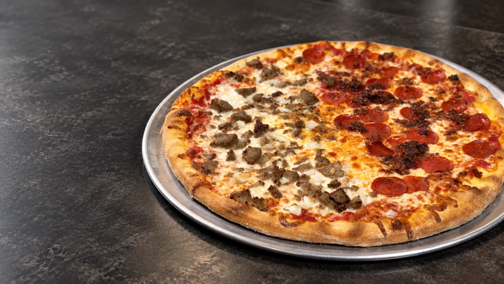 A half sausage and half pepperoni Joe Cristiano’s pizza on a metal tray